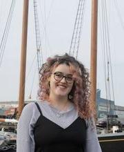 卡洛琳·金，23岁，在一艘帆船前摆姿势